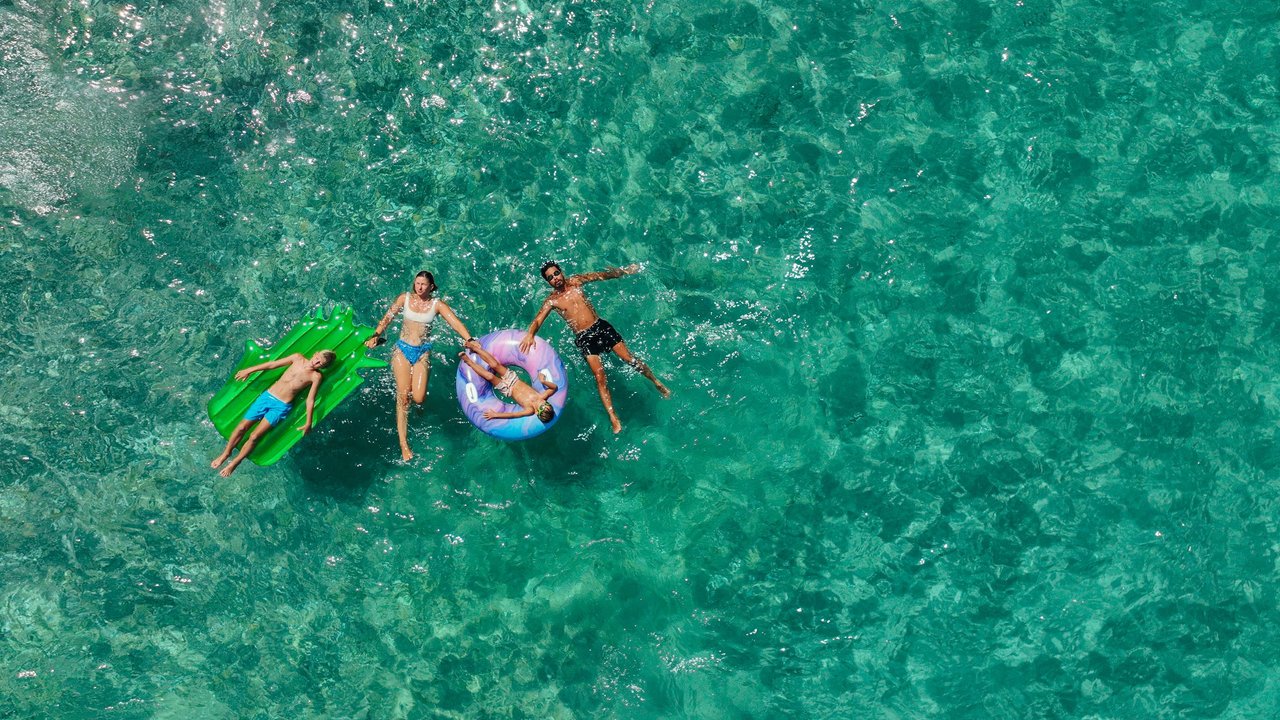 Photo of happy family relaxing in a sea water on inflatable swimming rings