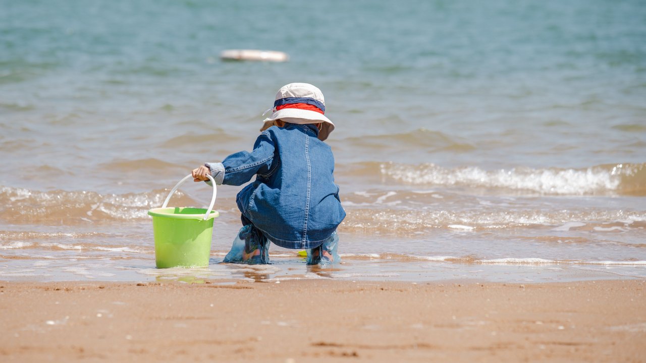 Ein kleines Kind spielt am Strand