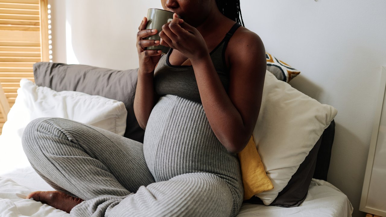Erkältung in der Schwangerschaft: Schwangere trinkt Tee im Bett