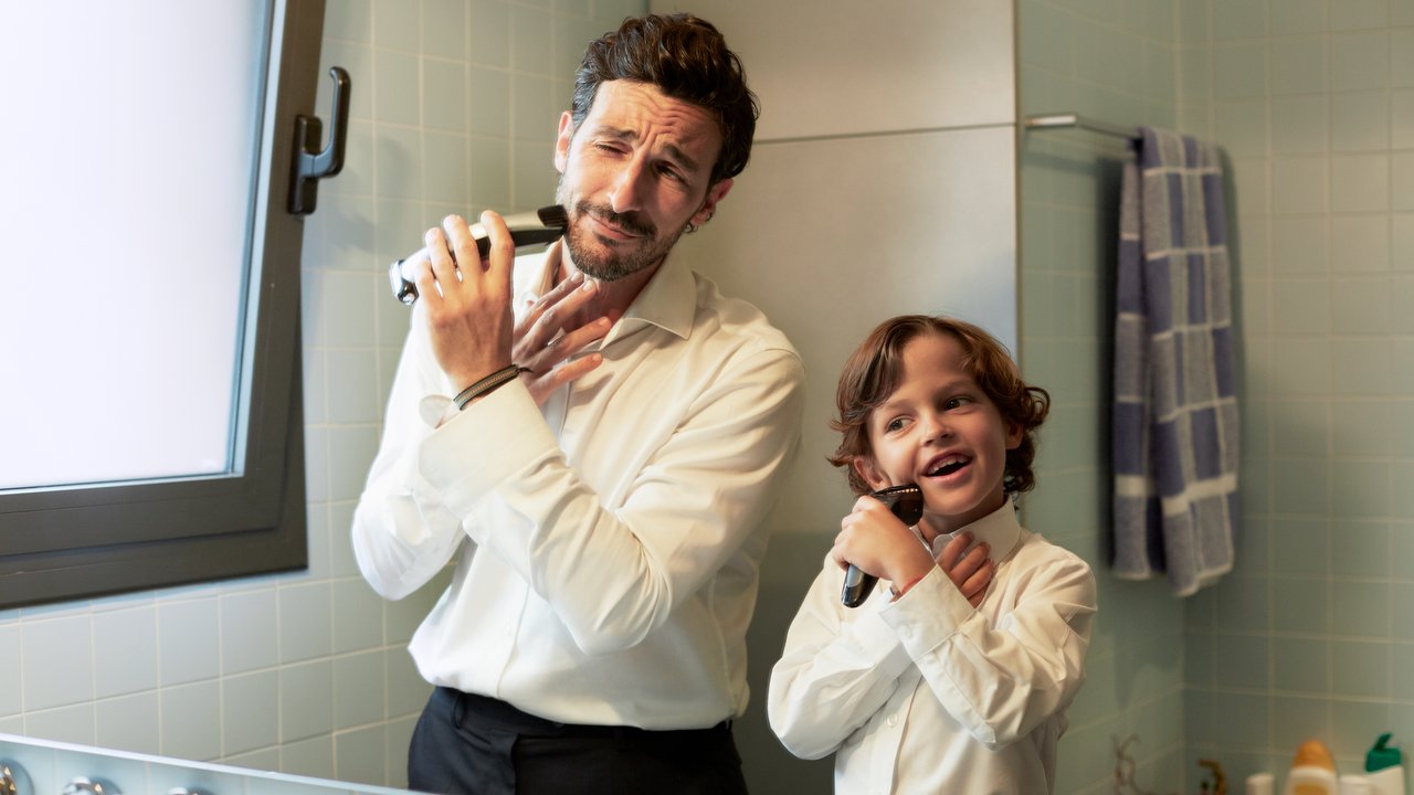 Reflection of father and son shaving together