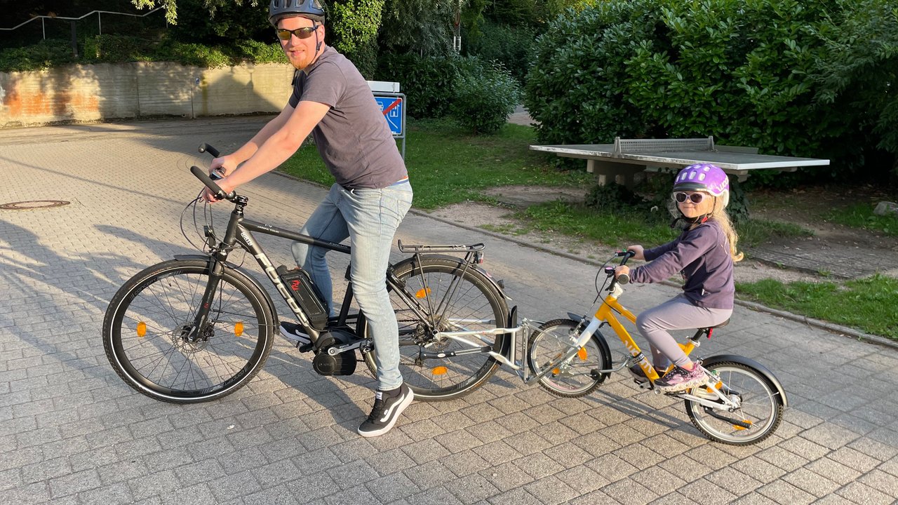 Tandemstange Fahrrad: Mann auf E-Bike schleppt Kind mit Tandemstange ab