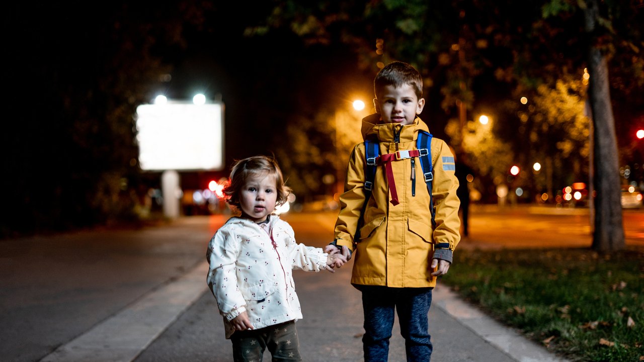 Kinder auf dem Weg zur Schule im dunklen Herbst