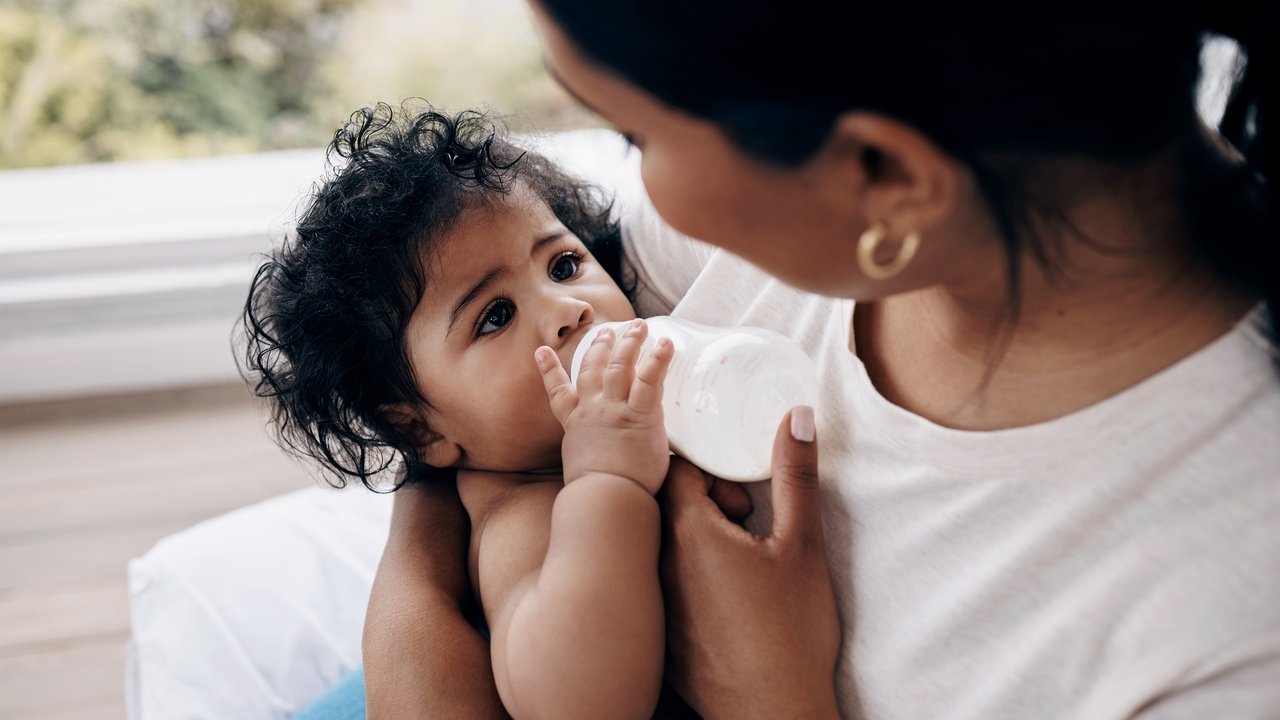 Babymilch Test: Mama füttert Baby mit Fläschchen