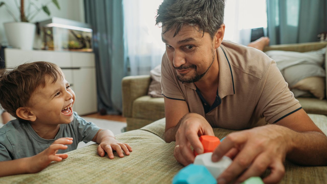 Happy boy playing with father on sofa at home model released, Symbolfoto property released, ANAF03764