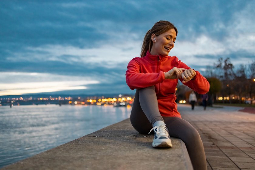 Sportliche Frau sieht auf ihre Smartwatch