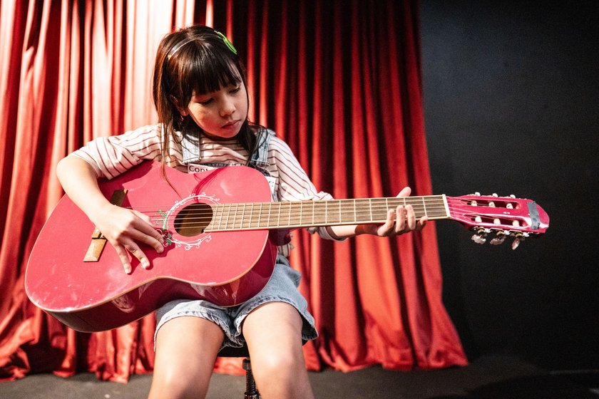Rührende Kindermomente: Kind spielt Gitarre auf Bühne
