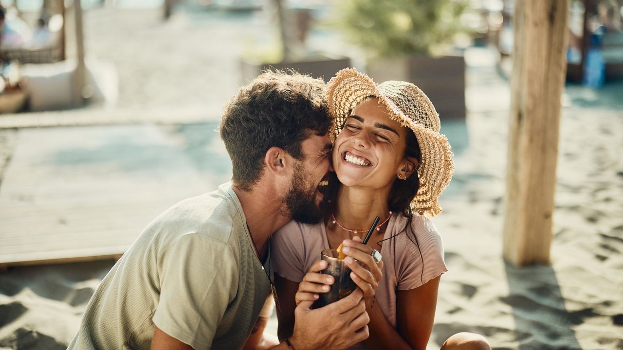 Glückliches Pärchen lachend am Strand