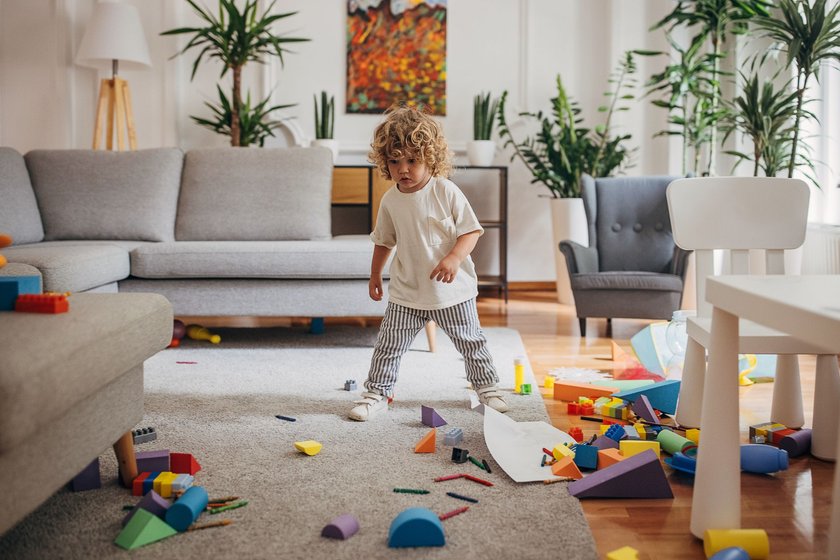 One boy, cute little boy playing alone in living room at home.