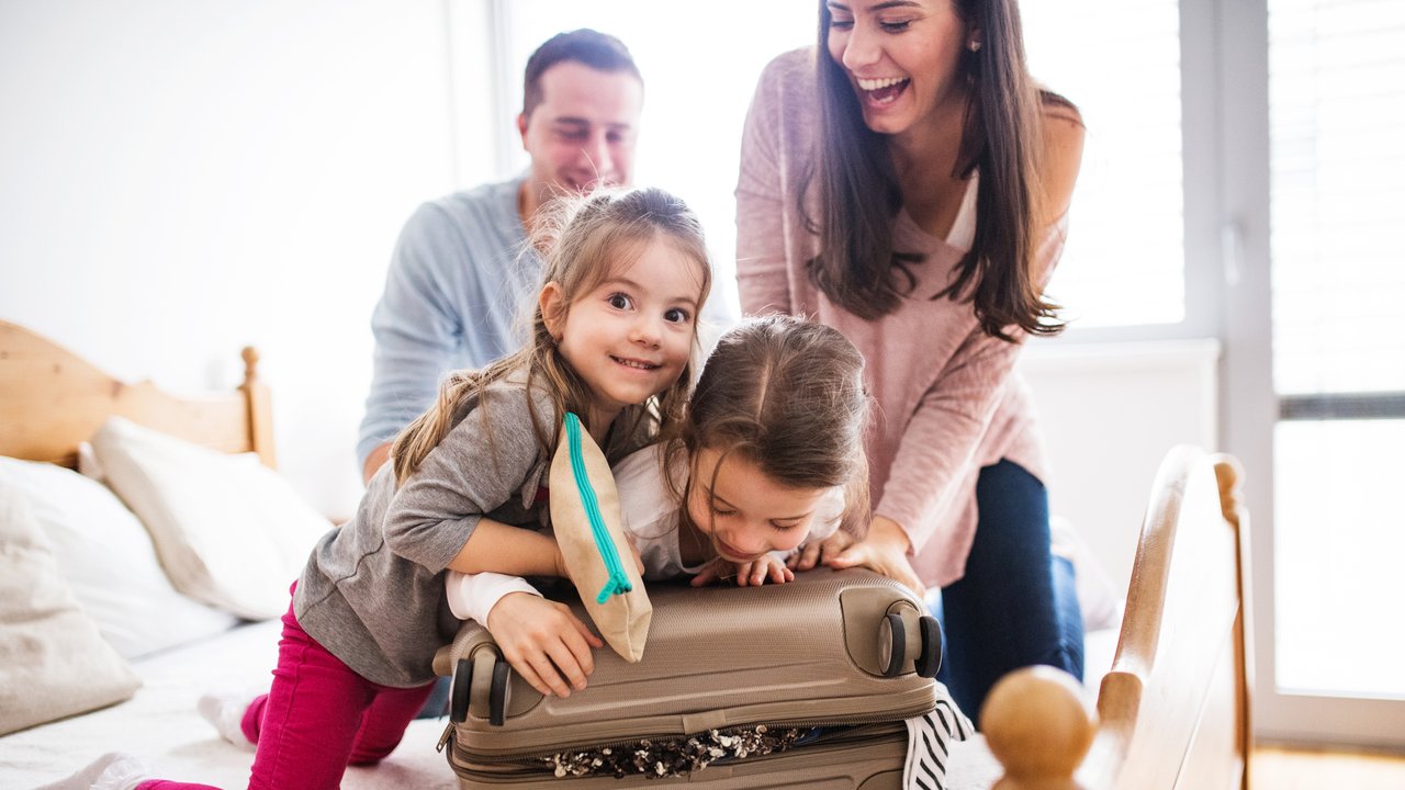 Reiserücktrittsversicherung: Familie beim Kofferpacken