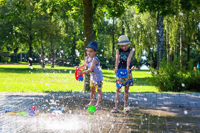 Zwei Kinder spielen am Wasserspielplatz an der Badestelle in Hagnau am Bodensee.
