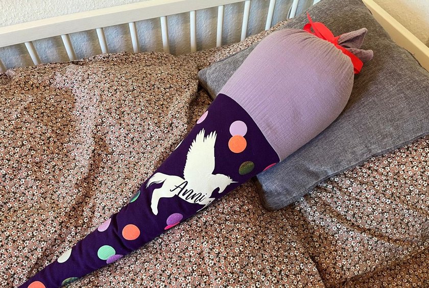 Schultüte lila liegt als Kissen in Kinderbett