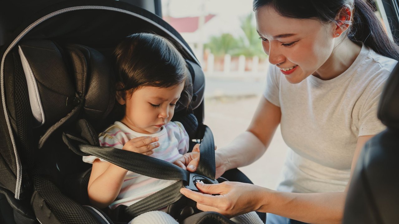 Gebrauchte Kindersitze: Mutter schnallt ihr Kind an