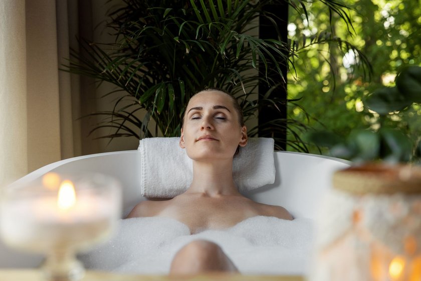 Frau entspannt sich bei Kerzen in der Badewanne