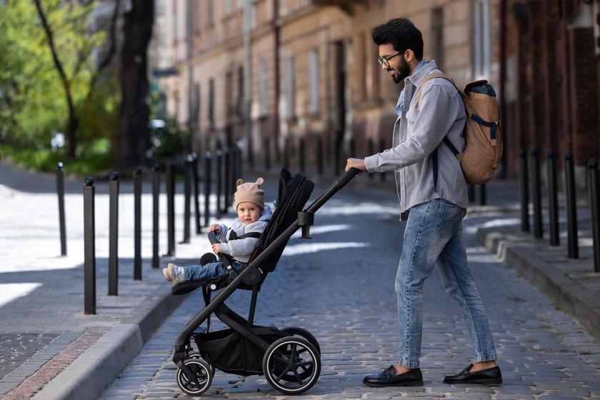 Mann schiebt einen Kinderwagen