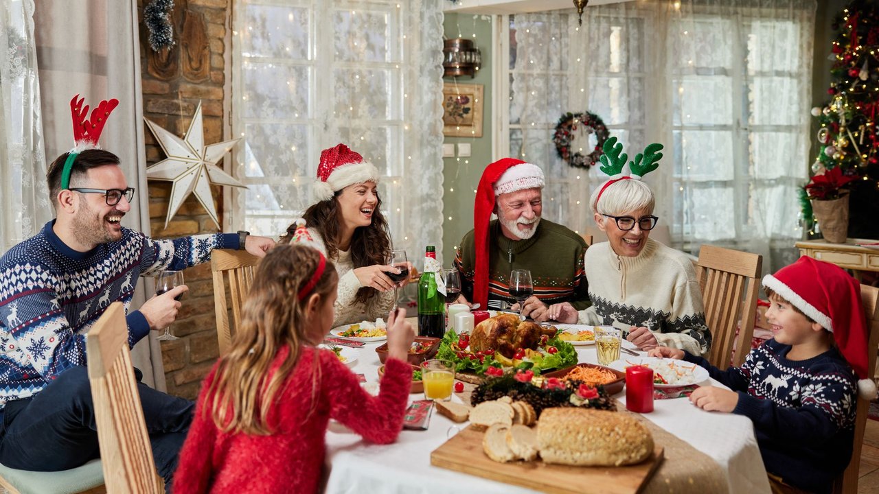 Familie sitzt am Essenstisch und feiert Weihnachten