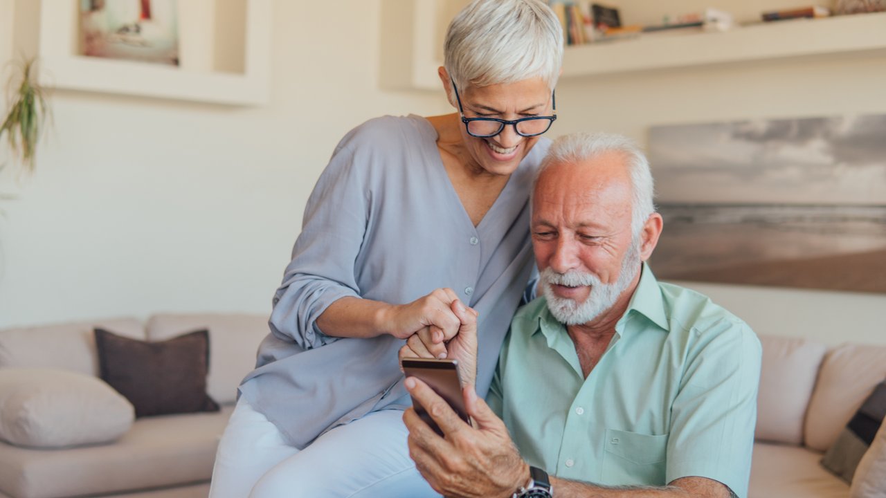Seniorenhandy-Test - Frau und Mann schauen auf Handy