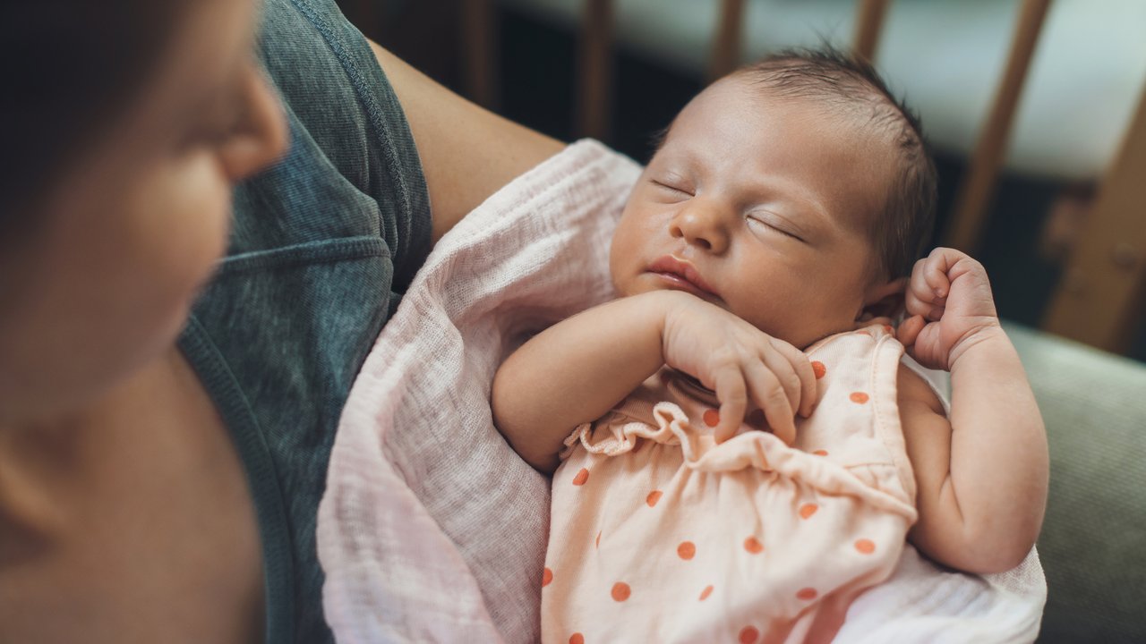 Schlafrhythmus Baby: Mama wiegt Baby in den Schlaf