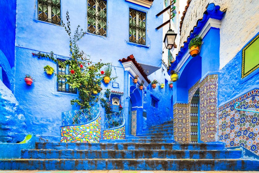 Blaue Gasse mit bunten Blumentöpfen in Chefchaouen, Marokko