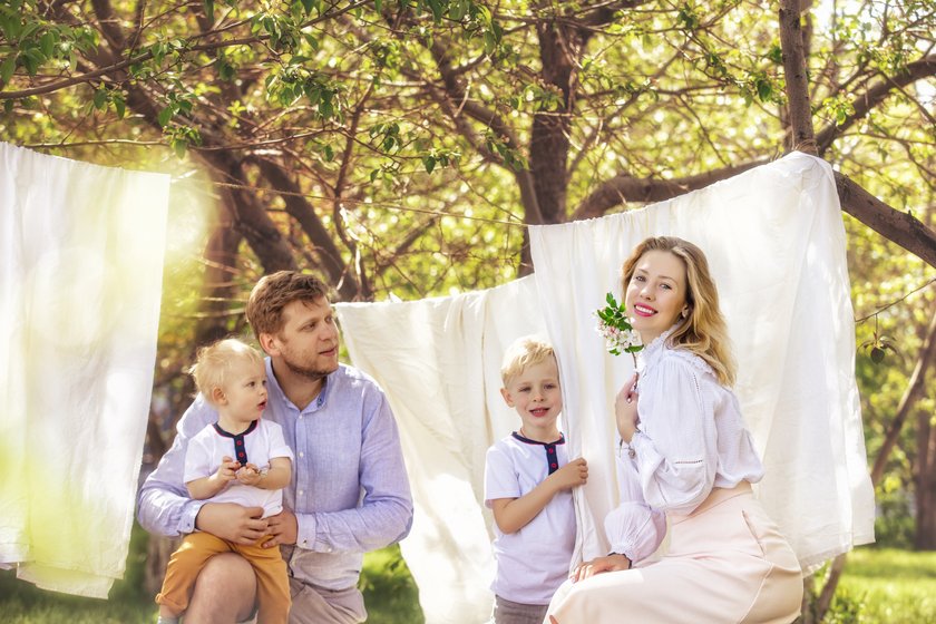 witzige Bilder Familie kniet in weißer Kleidung vor weißer Wäsche