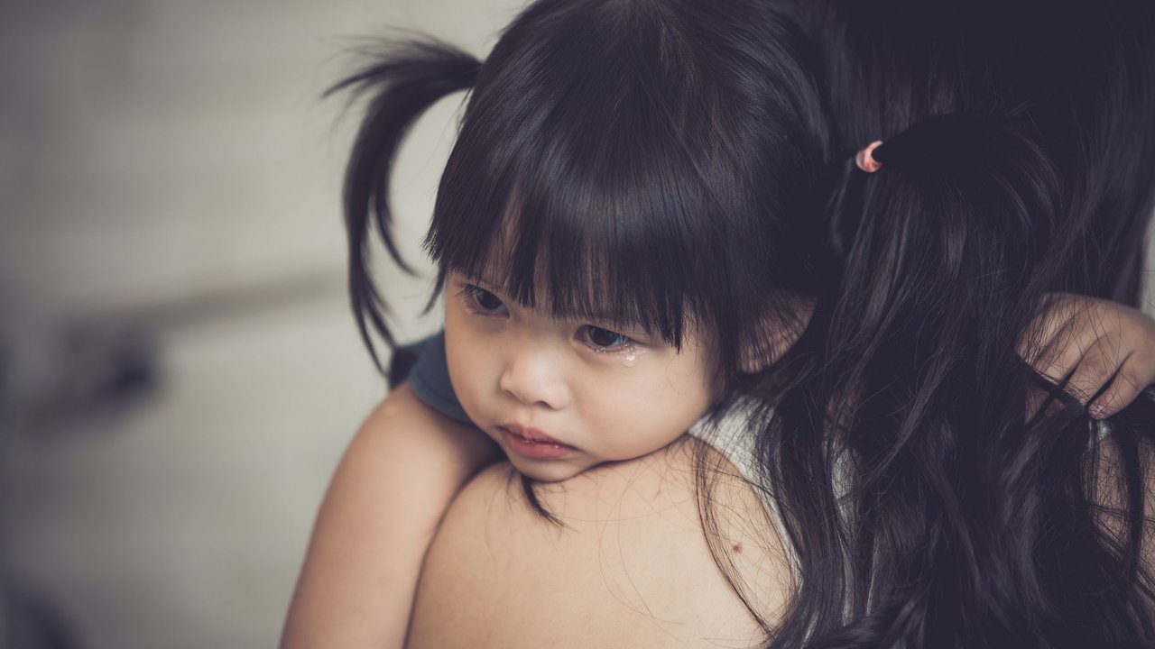 Wutanfall beim Kleinkind: Mama hält weinendes Kind auf dem Arm