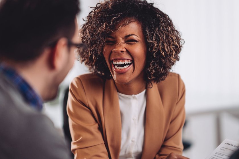 Smalltalk-Tipps: Frau lacht im Gespräch