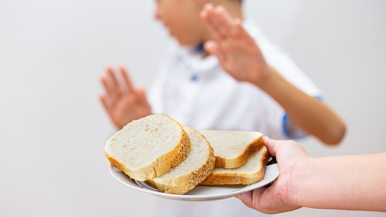 Gluten intolerance and diet concept. Kid refuses to eat white bread. Selective focus on bread