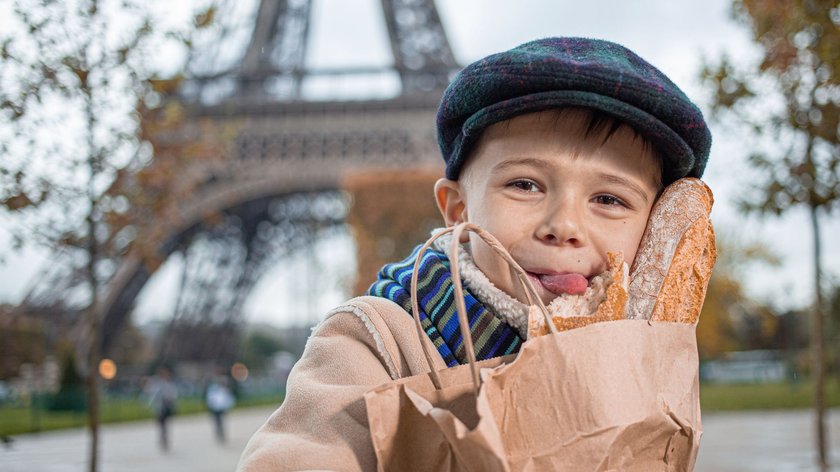 Kleiner Junge mit Baguette vor dem Eiffelturm