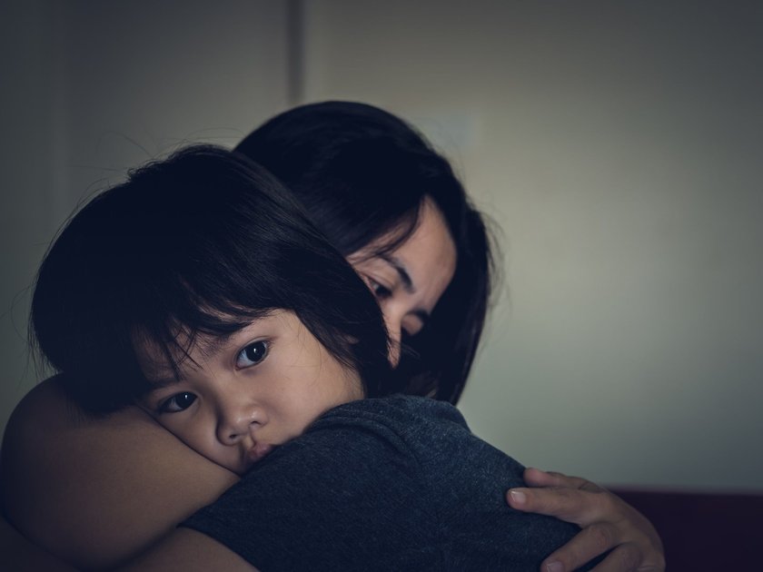 Kind zieht sich zurück: Mama umarmt trauriges Kind