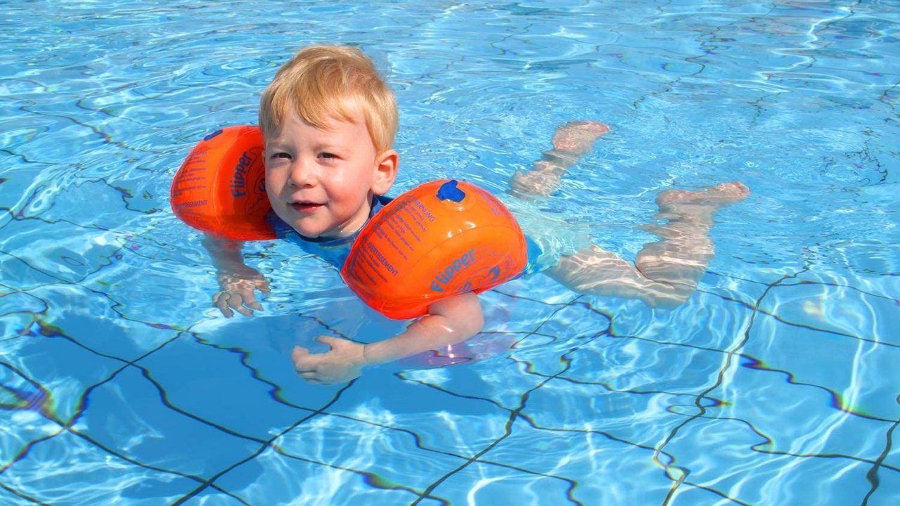 Kind im Pool mit Flipper Swimsafe Schwimmflügel