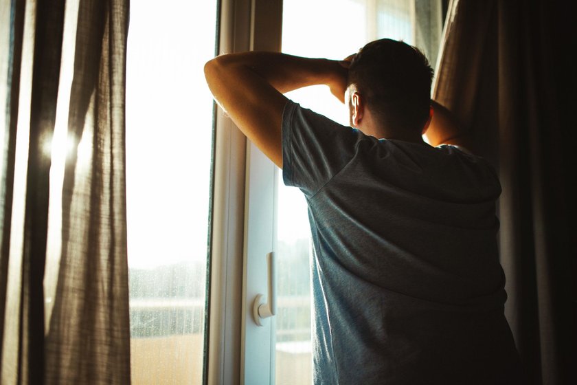 Tipps gegen Lustlosigkeit beim Mann: Mann steht besorgt am Fenster