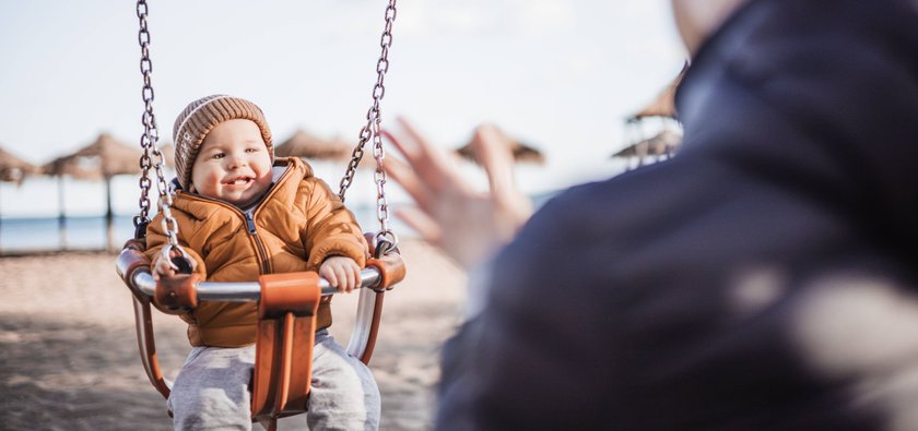 Mother pushing her cheerful infant baby boy child on a swing on sandy beach playground outdoors on nice sunny cold winter day in Malaga, Spain. Mother pushing her cheerful infant baby boy child on a swing on sandy beach playground outdoors on nice sunny cold winter day in Malaga, Spain Copyright: xZoonar.com/MatejxKastelicx 20514402