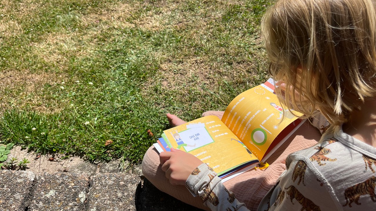 Freundebuch Kindergarten: Junge blättert in Ausfüllbuch