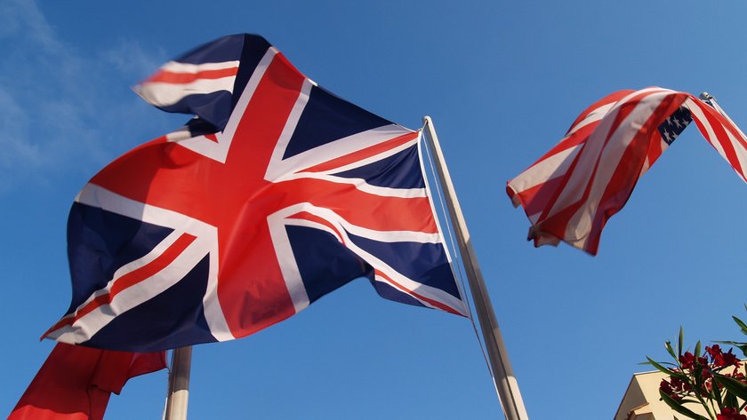 Verschiedene Flaggen englischsprachiger Länder vor einem blauen Himmel