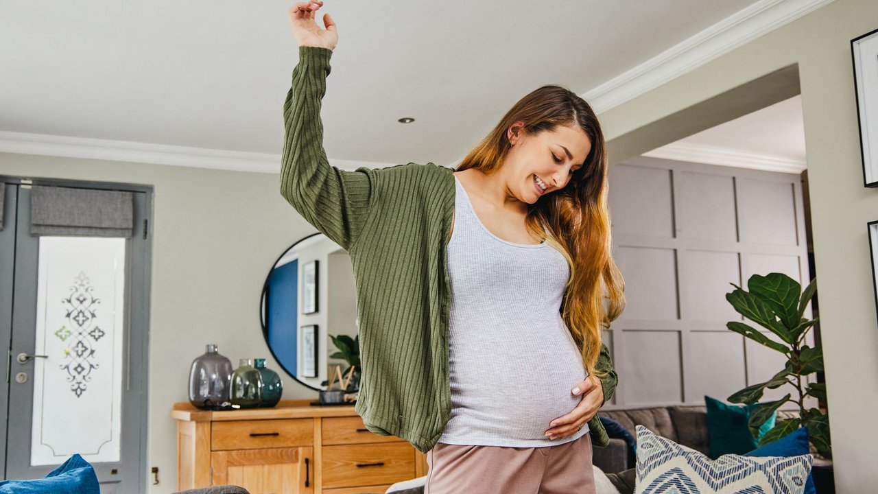 In die Wehen tanzen: Schwangere tanzt in ihrem Wohnzimmer, um die Wehen einzuleiten.