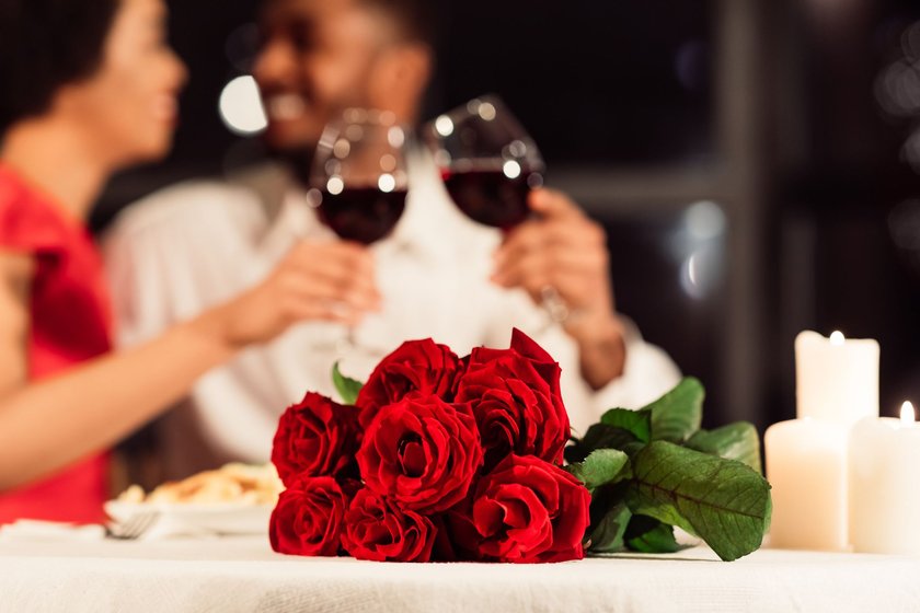 Romantisches Date in einem Restaurant mit Rosen auf dem Tisch und Wein