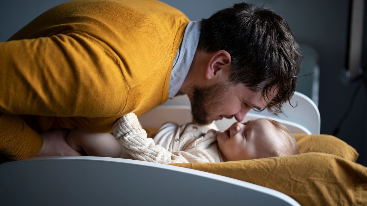 10 Dinge, die Erstlingseltern Angst machen können: Papa kuschelt mit seinem Baby auf dem Wickeltisch.