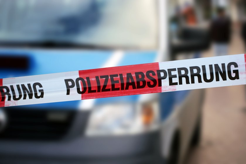 Police cordon tape with a police car in the background (Germany)