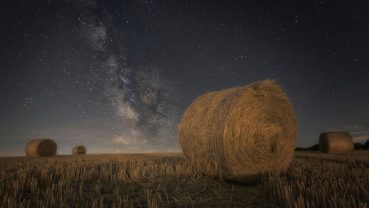 Heuballen auf einem Feld bei Nacht