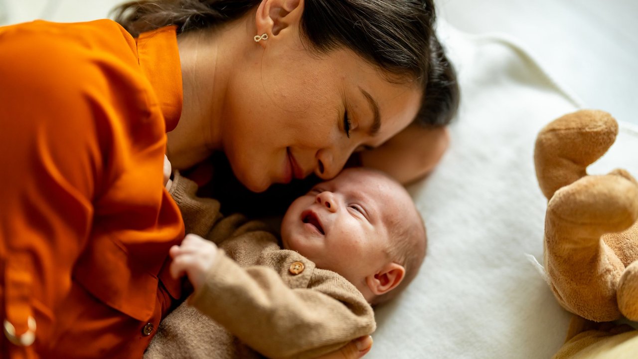 Young mother and baby napping at home