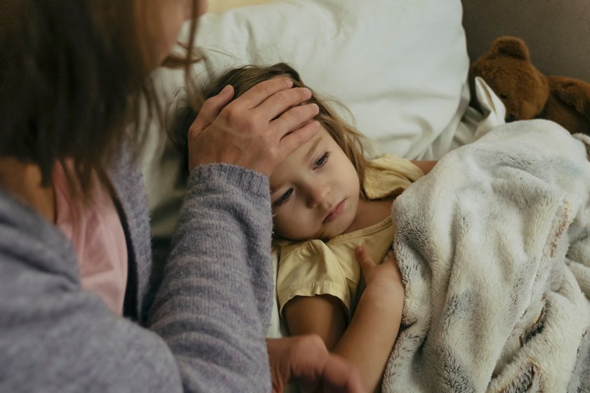 Kinderbuch Krankenhaus: Mama kuschelt mit krankem Kind in Bett