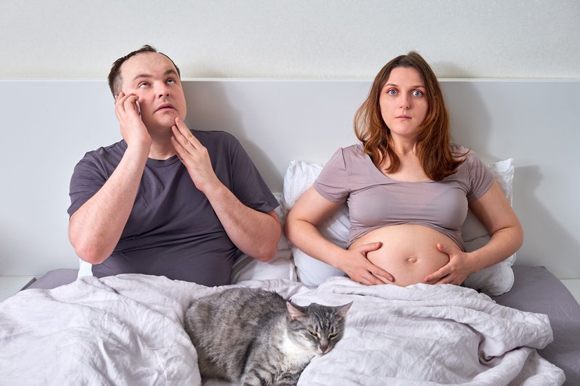 Mann und schwangere Frau im Bett