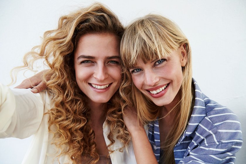 Blondinen Witze: Zwei blonde Frauen lachen in die Kamera