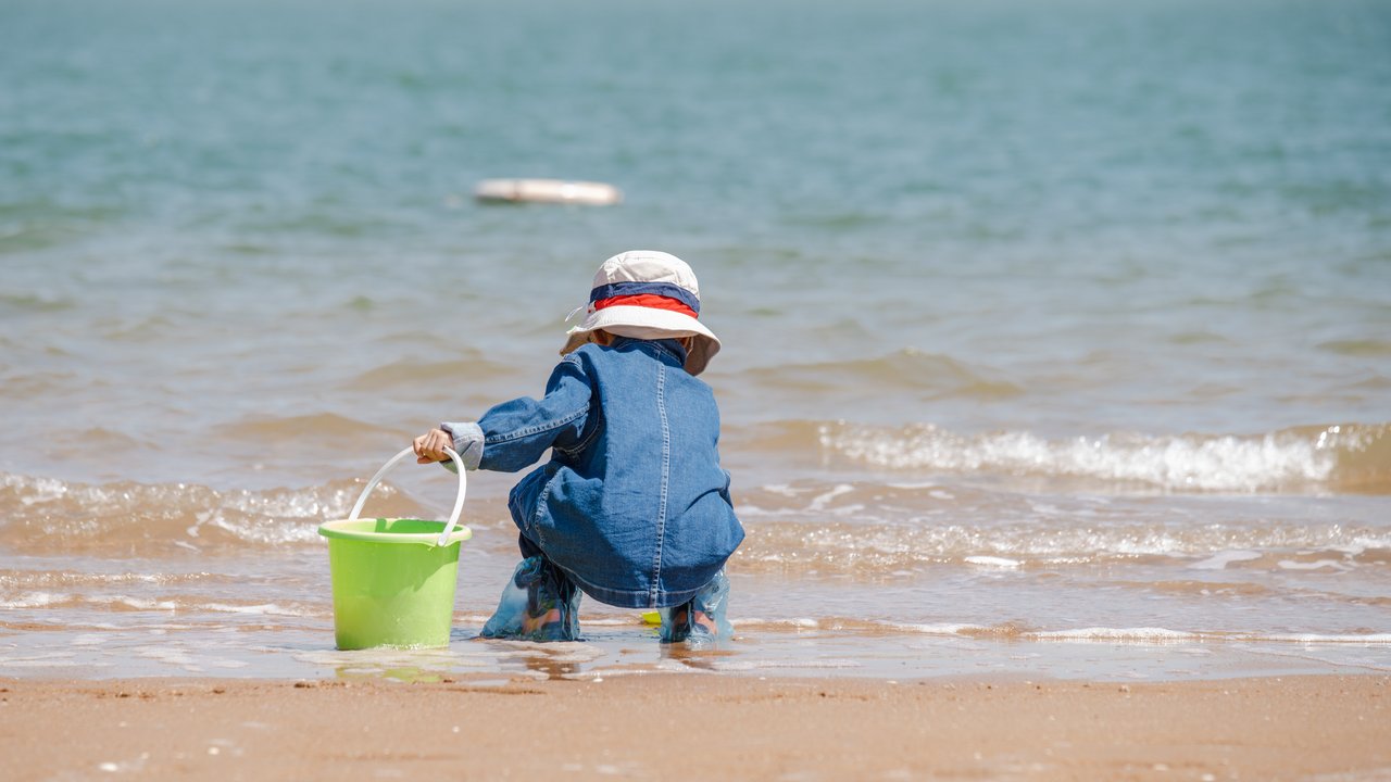 Ein kleines Kind spielt am Strand