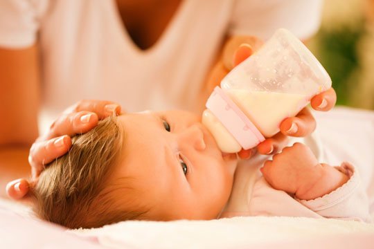 Baby wird mit Babyflasche gefüttert