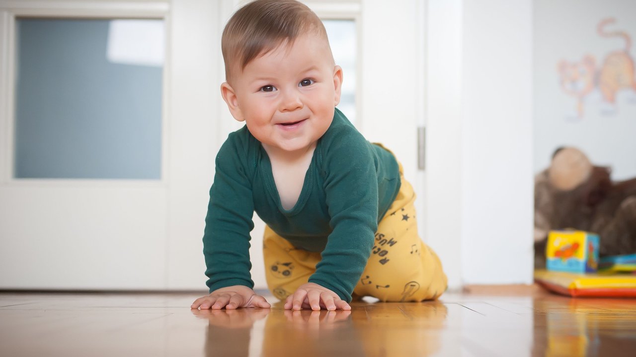 Baby krabbelt mit Krabbelhose für Babys