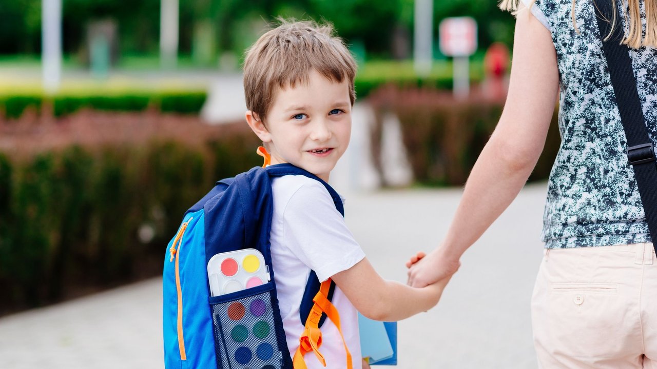 Checkliste Einschulung: Junge geht mit Mutter in die Schule