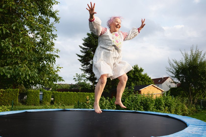 Von Kindern lernen: Seniorin springt auf einem Trampolin