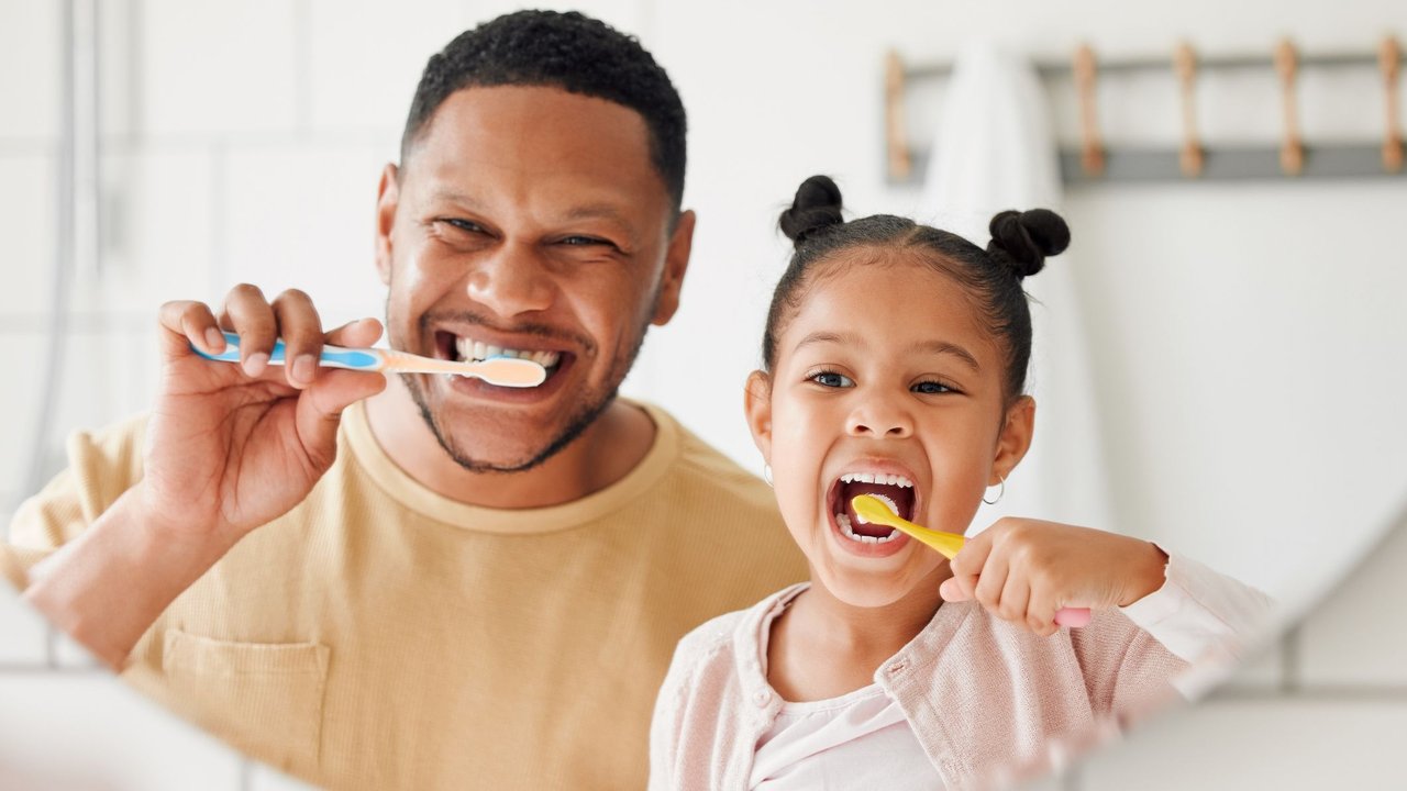 Zahnpasta-Test . Vater und Tochter putzen Zähne
