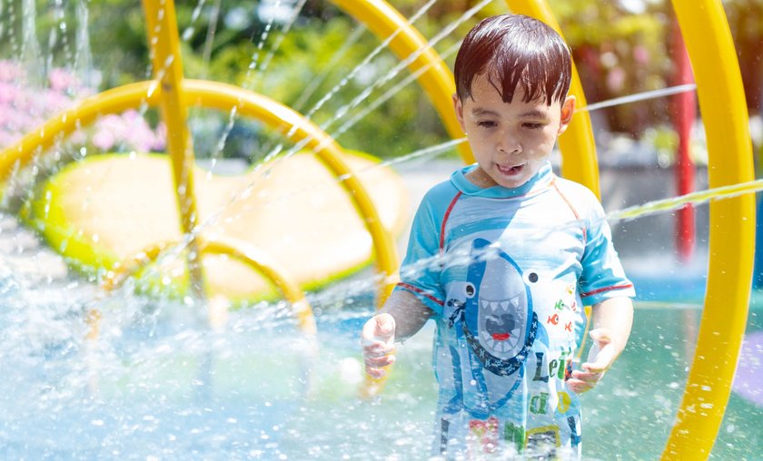 Wasserspiel für Kinder: Junge spielt im Wasser
