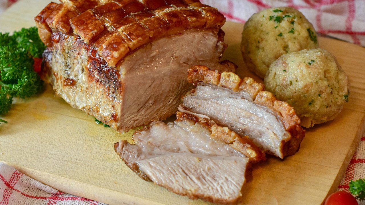 Schweinekrustenbraten wird häufig mit Knödeln serviert.